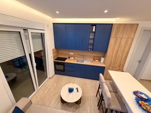 a kitchen with blue cabinets and a table and chairs at IK Apartments in Rake