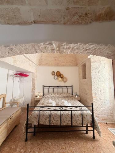 a bedroom with a bed in a stone wall at La casetta di zia Giuseppina in Alberobello