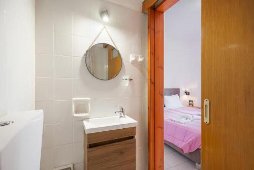 a bathroom with a sink and a mirror and a bed at Dionysus House Lasithi Plateau in Magoulás
