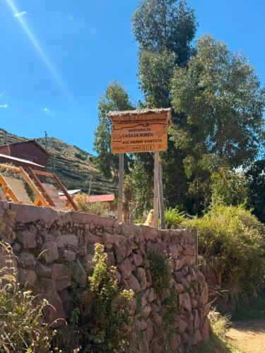 a sign that is next to a stone wall at Casa de Ruben - Lac Titicaca in Llachon