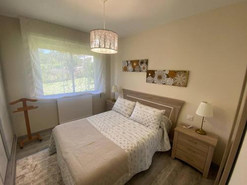 a small bedroom with a bed and a window at Lar de Mamita in Cristiñade
