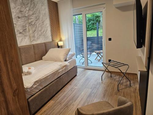 a living room with a bed and a balcony at Zasavski Gurman in Dol pri Hrastniku