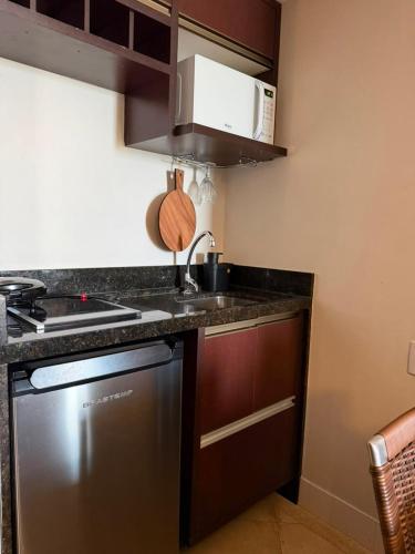 a kitchen with a sink and a stove top oven at Tropical Executive Confort in Manaus