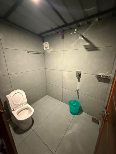 a small bathroom with a toilet and a bucket at Skydeck - Boche 1000 Acre in Meppādi