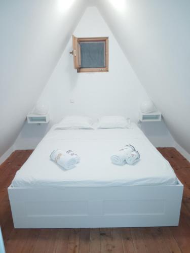 a white bed in a room with a window at Bungalov A in Sveti Filip i Jakov