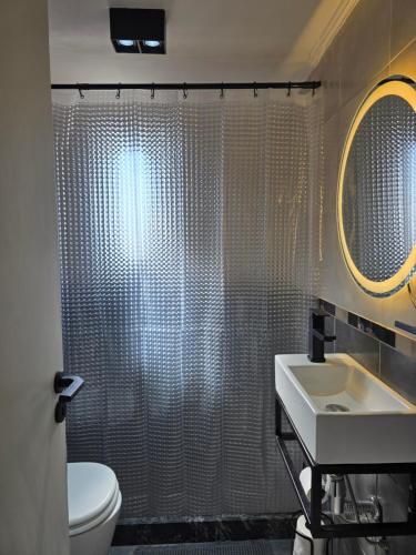a bathroom with a shower with a sink and a toilet at NAT home in San Lorenzo