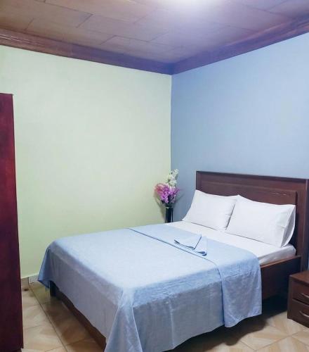 a bedroom with a large bed with white sheets at M & S Multipurpose Center in Yaoundé