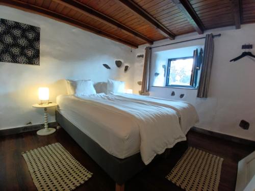 a bedroom with a large bed with a window at Casa dos Santos Historic Azorean Estate in Horta