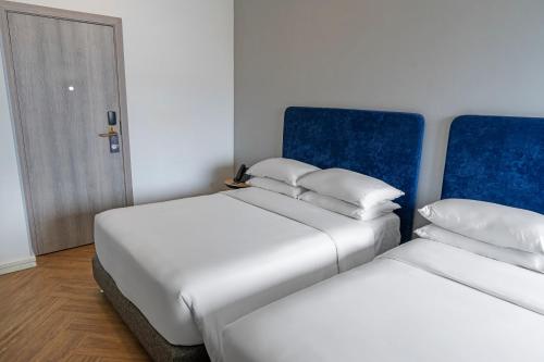 two beds sitting next to each other in a room at Faranda Collection Cali, a member of Radisson Individuals in Cali