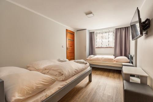 シュクラルスカ・ポレンバにあるWilla Brylantのベッドルーム(ベッド2台、テレビ付)
