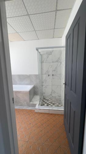 a bathroom with a shower with a tub at River Gates Home in Rundu