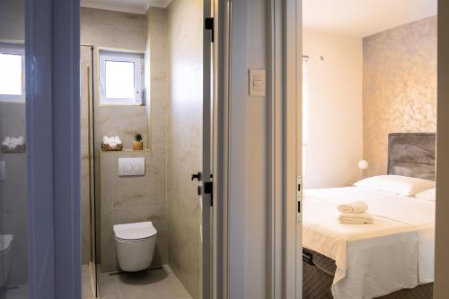 a bathroom with a bed and a toilet in a room at Lighthouse Kotor in Prčanj