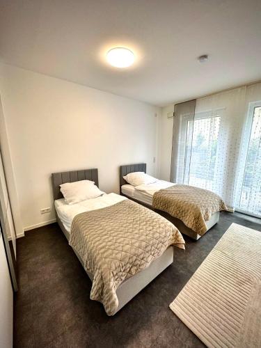 a bedroom with two beds and a window at Luxuriöse Apartment in Bochum