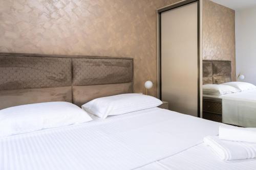 a bedroom with two beds and a mirror at Lighthouse Kotor in Prčanj