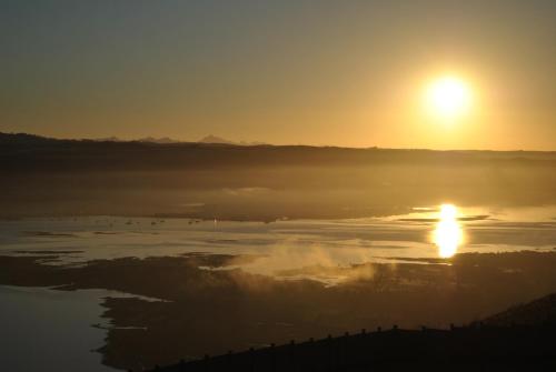 a sunrise over a body of water with the sun in the sky at Villa Castollini in Brenton-on-Sea