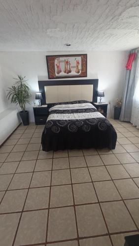 a bedroom with a bed on a tiled floor at Posada del Jardín in Huasca de Ocampo