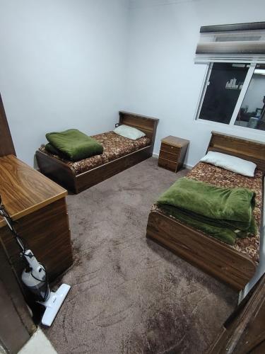 ein Zimmer mit drei Betten und einem Fenster in der Unterkunft ريماس 13 in Irbid