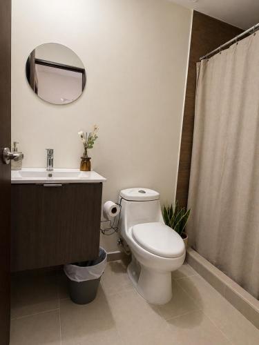 a bathroom with a toilet and a sink and a mirror at Apto de Paula in San Salvador