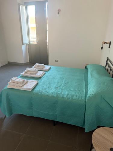 a green bed with towels on top of it at La dimora del borgo antico in Pulsano