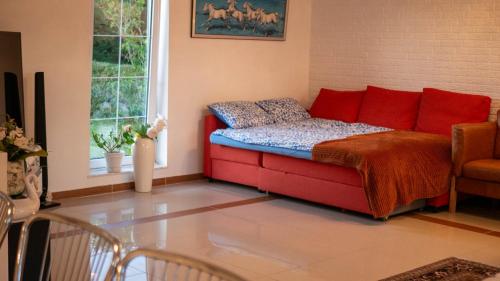 a bedroom with a bed with red and blue pillows at Amazing villa with garden in Kolding
