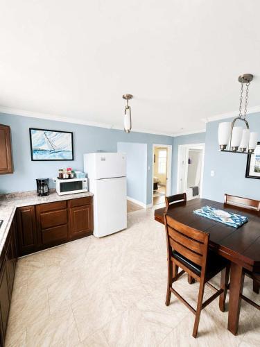 a kitchen with a table and a white refrigerator at Whistler's View in Twillingate