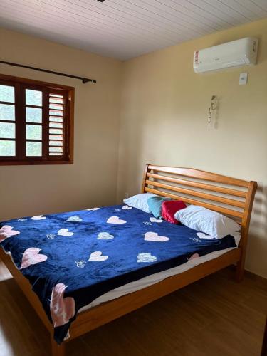 a bedroom with a bed with a blue comforter and pillows at Recanto da Julie in Mulungu