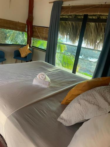 a bedroom with a bed with a towel on it at Punta El Zonte in El Zonte