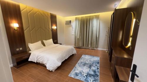 a bedroom with a white bed and a refrigerator at شقق احد رفيدة in Ahad Rafidah