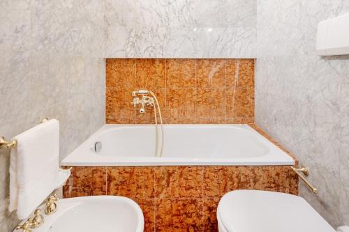 a bathroom with a tub and a toilet and a sink at Arezzo Centre, Prestigious Apartment with a View in Arezzo