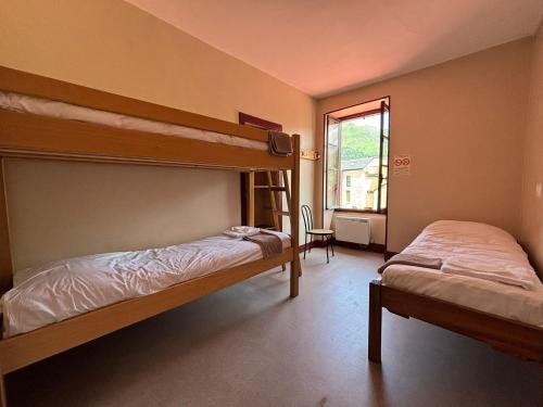 two bunk beds in a room with a window at L'Embaradere in Laruns