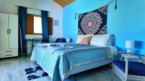 a blue bedroom with a bed and a blue wall at Casa Velho 05 Rodrigues in Órgãos