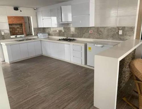 a kitchen with white cabinets and a wooden floor at Hipolito in La Serena