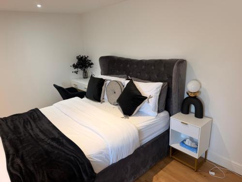 a large bed with a black headboard in a bedroom at Gatwick LUXURY STUDIO FLAT in Crawley