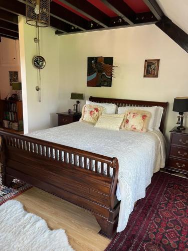 a bedroom with a large wooden bed with pillows at La Chouette in Beynat