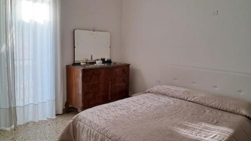 a bedroom with a bed and a dresser with a mirror at Affitti Brevi da Rita in Monte di Procida