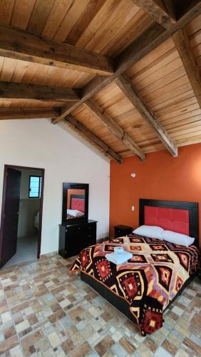 a bedroom with a large bed with orange walls at Cabaña Refugio del Silencio Ixmiquilpan in Ixmiquilpan