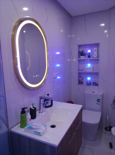 a bathroom with a sink and a mirror and a toilet at Villa Harmonie - Suite Familiale avec Piscine in Khemisset