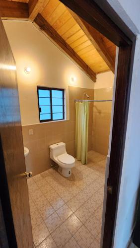 a bathroom with a toilet and a window and a shower at Cabaña Refugio del Silencio Ixmiquilpan in Ixmiquilpan