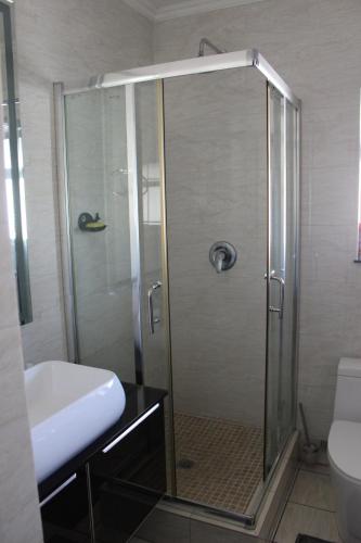 a shower with a glass door in a bathroom at First Gen Cedar Acres Fourways in Trevallyn