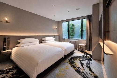 a bedroom with two beds and a large window at THE HOTEL HIGASHIYAMA KYOTO TOKYU, A Pan Pacific Hotel in Kyoto