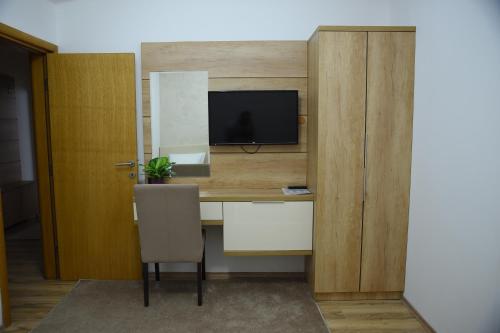 Una televisión o centro de entretenimiento en Garni Uni Elita Lux Hotel
