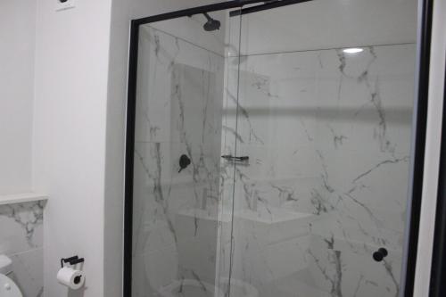 a shower with a glass door in a bathroom at First Gen lagoon facing luxury apartment in Pretoria