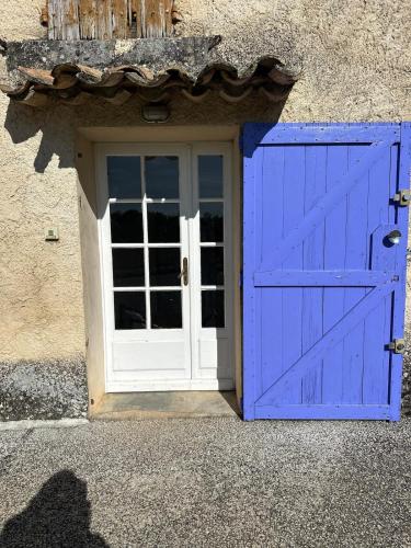 a blue door with a white window and a door at Maison Icard in Sault-de-Vaucluse