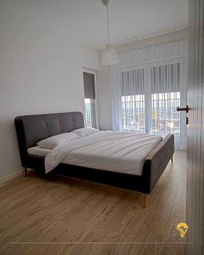 a large bed in a bedroom with a large window at Tian Vista Apartment in Prishtinë