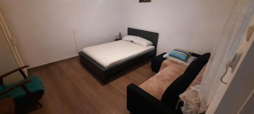 a small bedroom with a bed and a couch at Daria in Eforie Sud