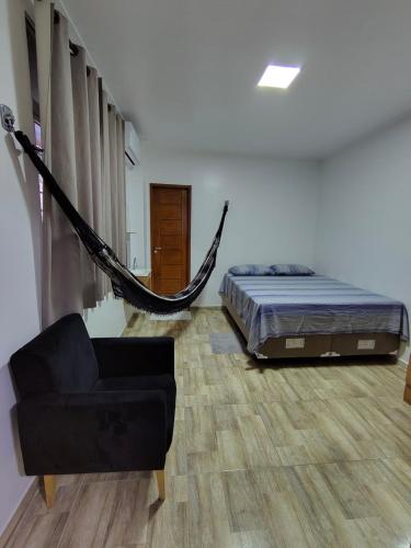 a bedroom with a hammock and a bed and a couch at Apartamento no Centro de Macapá - Edifício Fernando Dias in Macapá