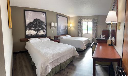 a hotel room with two beds and a desk at Knights Inn Hartford in Hartford