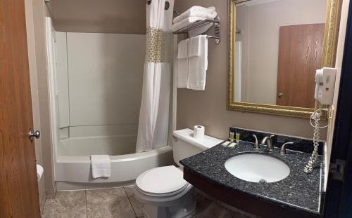 a bathroom with a toilet and a sink and a tub at Knights Inn Hartford in Hartford