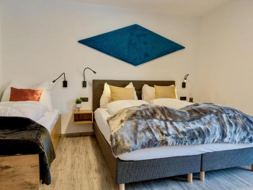 a bedroom with two beds and a painting on the wall at Bockblick Top 5 in Weisspriach
