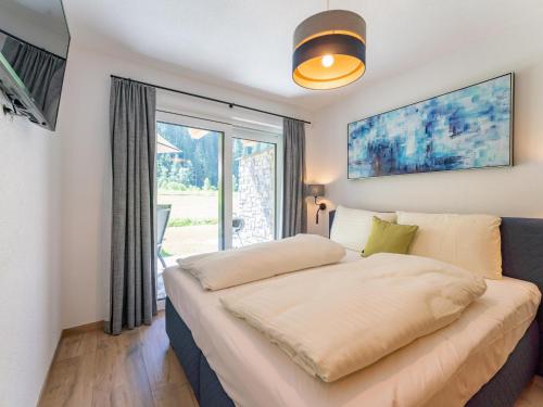 a bedroom with a large bed with a window at Felsener Wald in Wald im Pinzgau